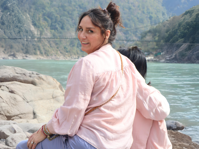 Yoga retreat group practicing pranayama by the Ganges river